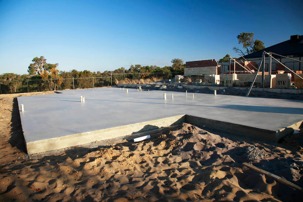 a large concrete slab that has been freshly poured by concreting Ballarat with all the pipes sticking out of it